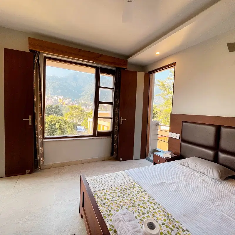Private course room with a double bed and a window onto the Himalayan foothills