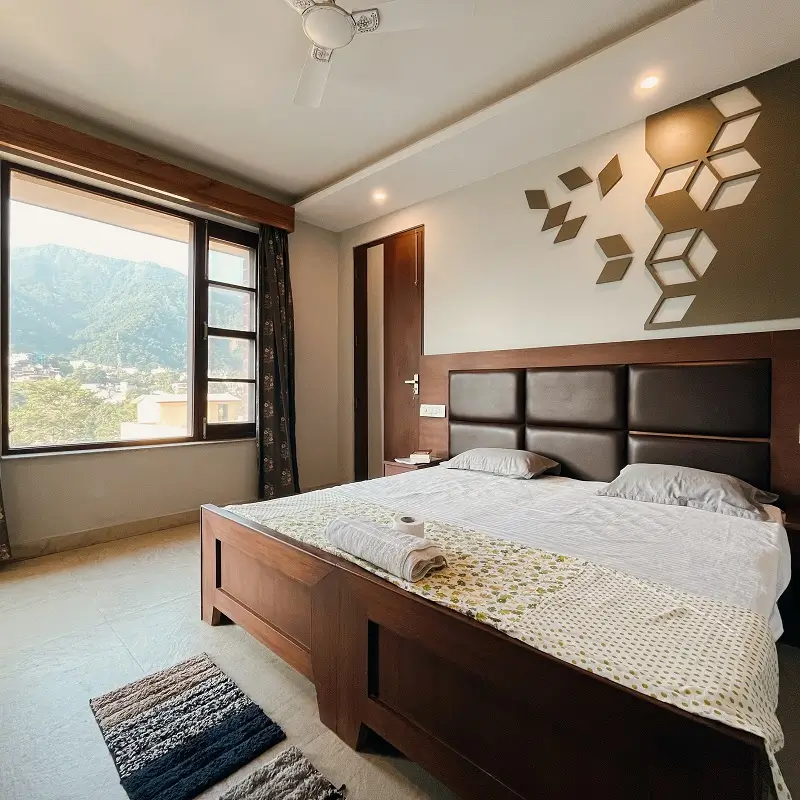 Comfortable twin room with balcony and Himalayan valley view for yoga teacher training students in Rishikesh