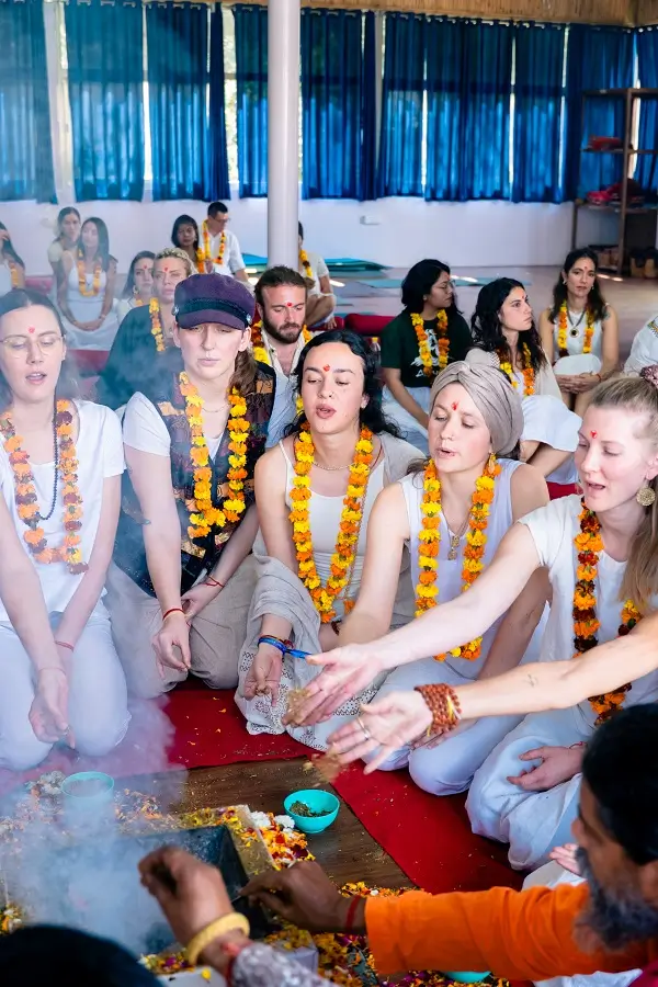 Student sitting cross-legged in the dark, eyes closed and hands resting in chin mudra